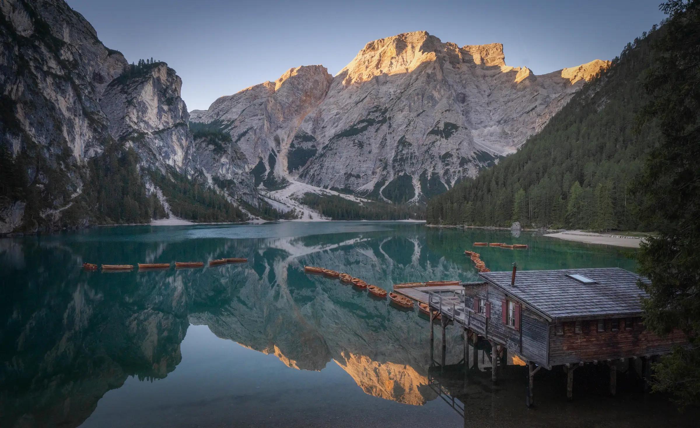Sunrise illuminating the Dolomites above the still waters of Lake Braies
